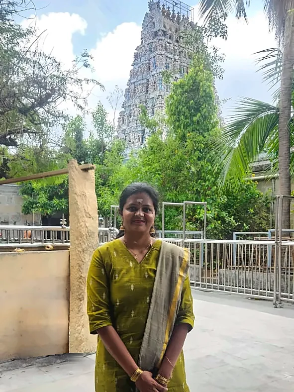 Ramadevi, founder of AA Gifts, standing in front of a temple tower
